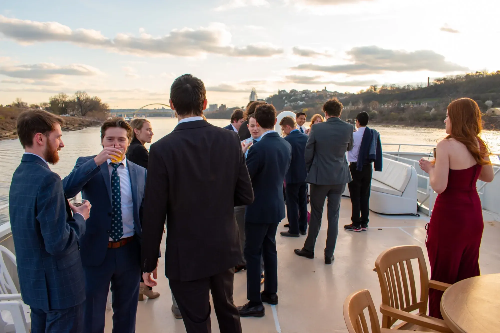 Fraternity and sorority members in formal wear on the top deck of The Destiny at golden hour