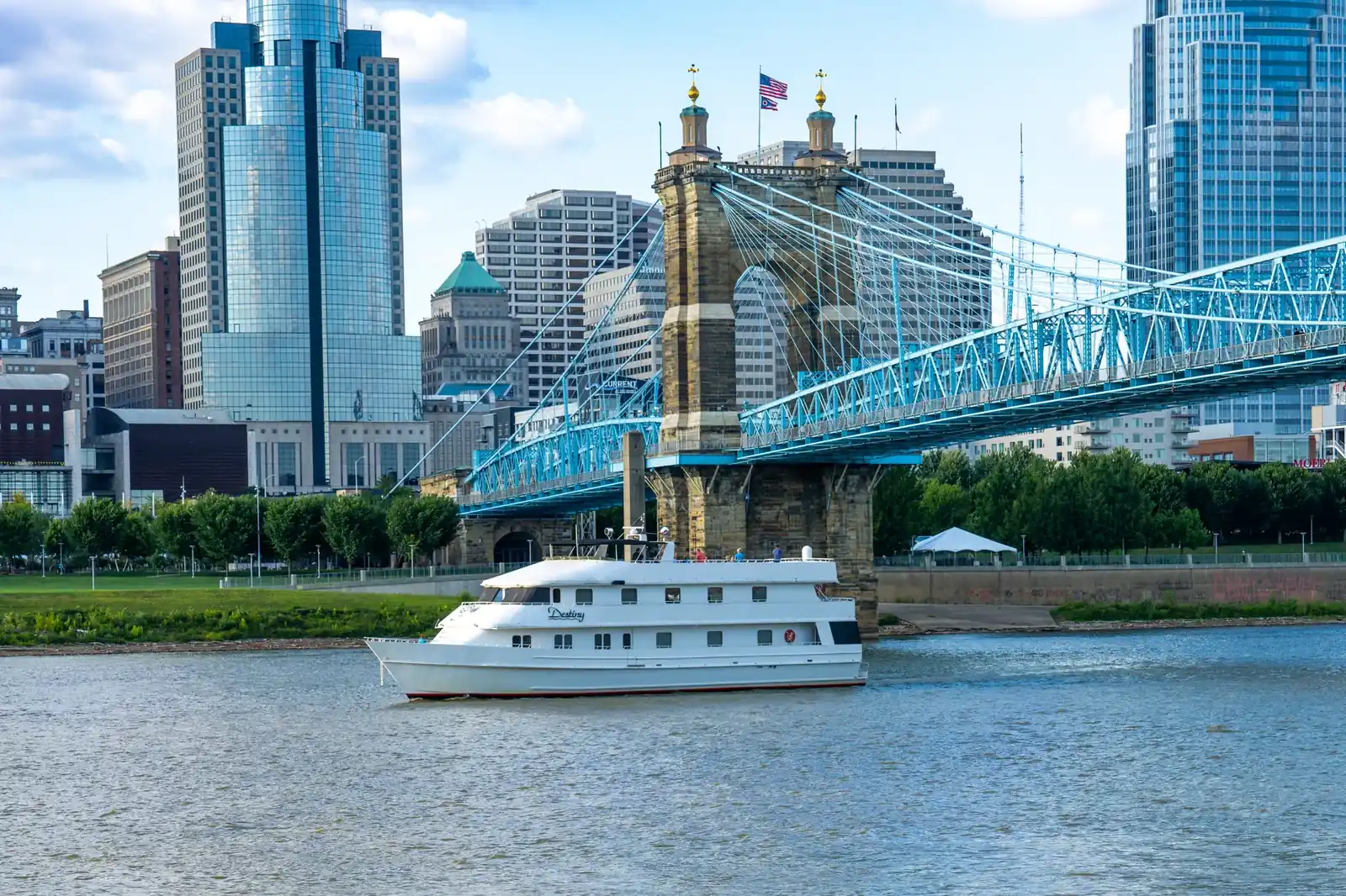 The Destiny cruising past the Roebling Suspension Bridge with the Cincinnati skyline behind her